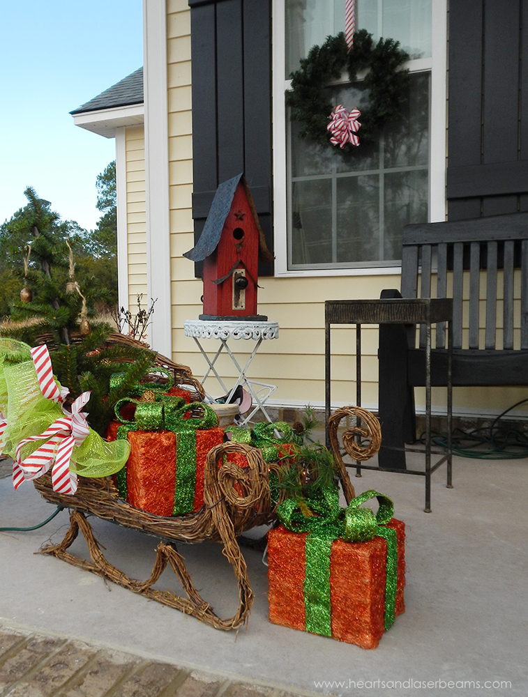 Front Porch decoration with a sleigh full of hearts, Laser beanms , garland & Gifts